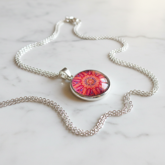 Red coral mandala petite pendant necklace angled view on marble surface