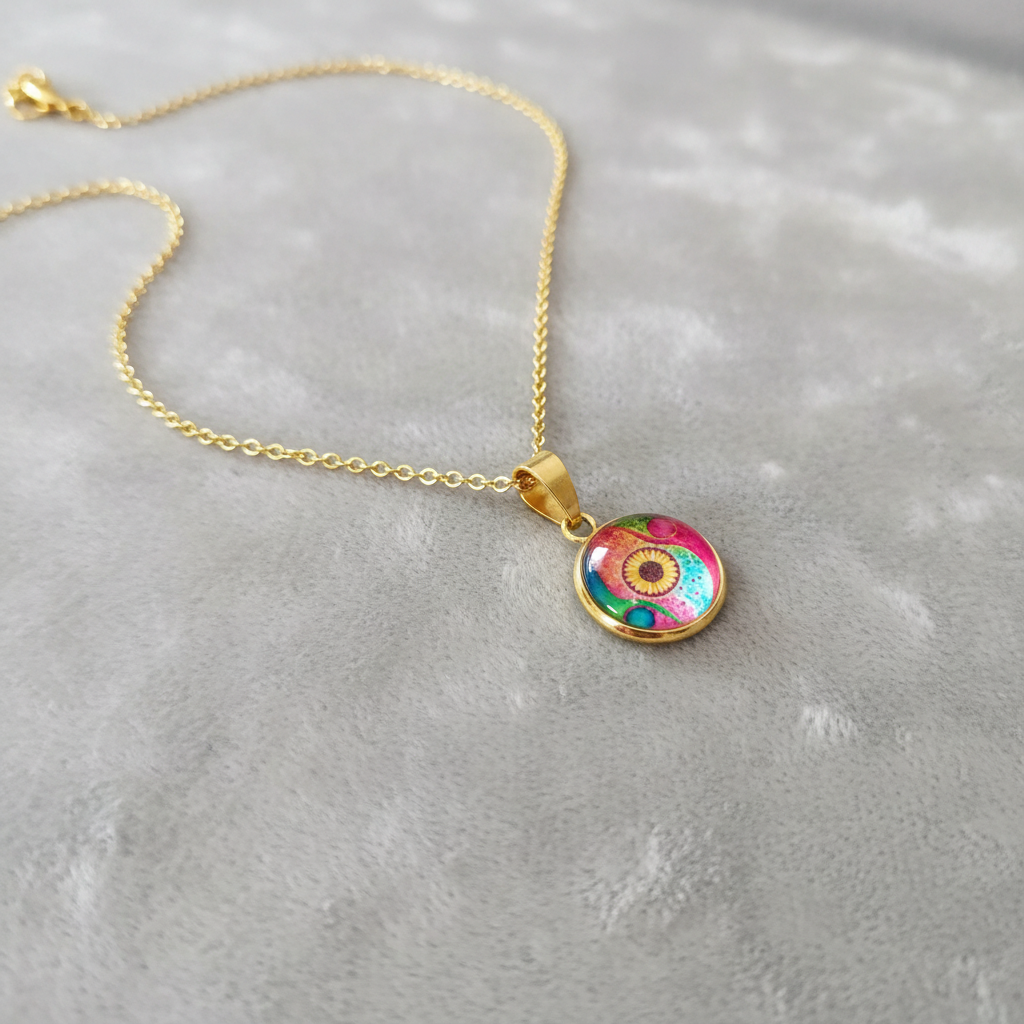 Angled view of petite abstract watercolor sunflower pendant on velvet background