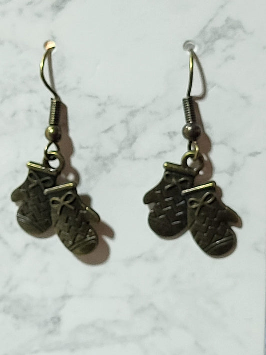 Antique bronze double mitten charm dangle earrings with knit texture and bow detail on bronze French wire on marble surface