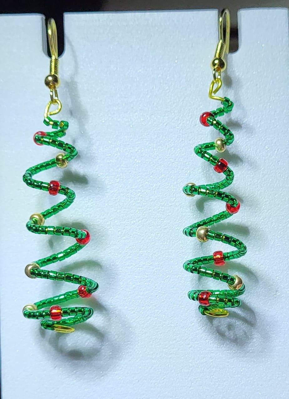 Handmade spiral wire Christmas tree earrings with green delica seed beads and red gold bead accents on gold lever-back ear wires on white earring card