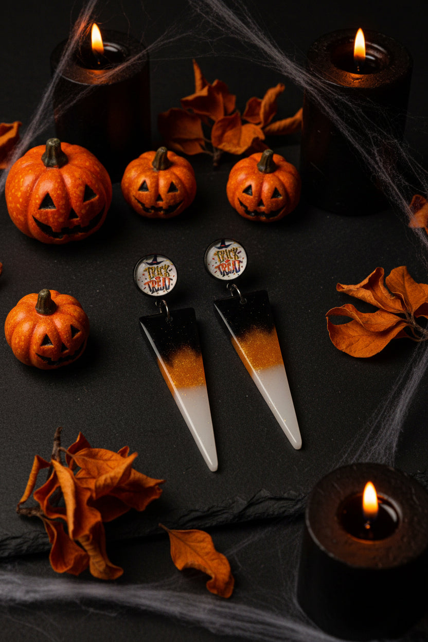 Black and orange gradient resin triangle dangle earrings with Trick or Treat photo cab studs on marble display card