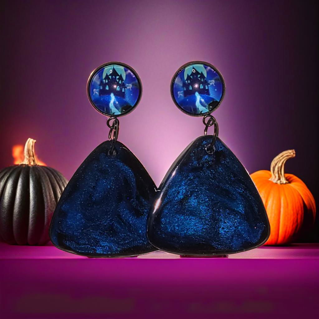 Midnight blue shimmer resin triangle Halloween earrings styled with pumpkins in purple and orange scene