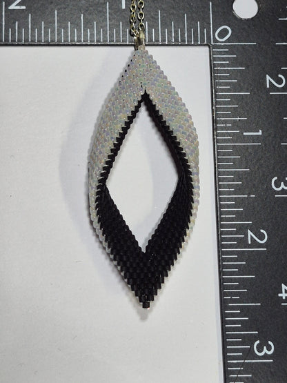 Black and white Miyuki Delica leaf pendant beside rulers showing its size.