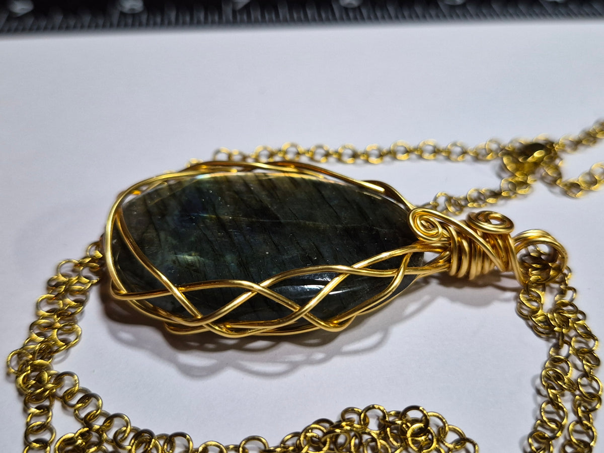 Side view of labradorite pendant showing the braided gold-tone copper wire frame.