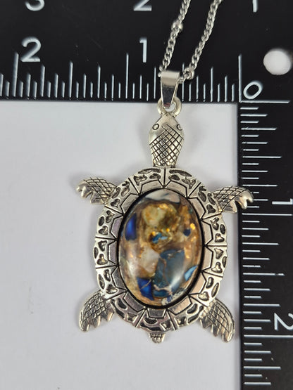 Mosaic-style cabochon sea turtle pendant beside a ruler for scale.