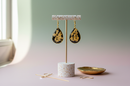 Black and gold earrings on contemporary display