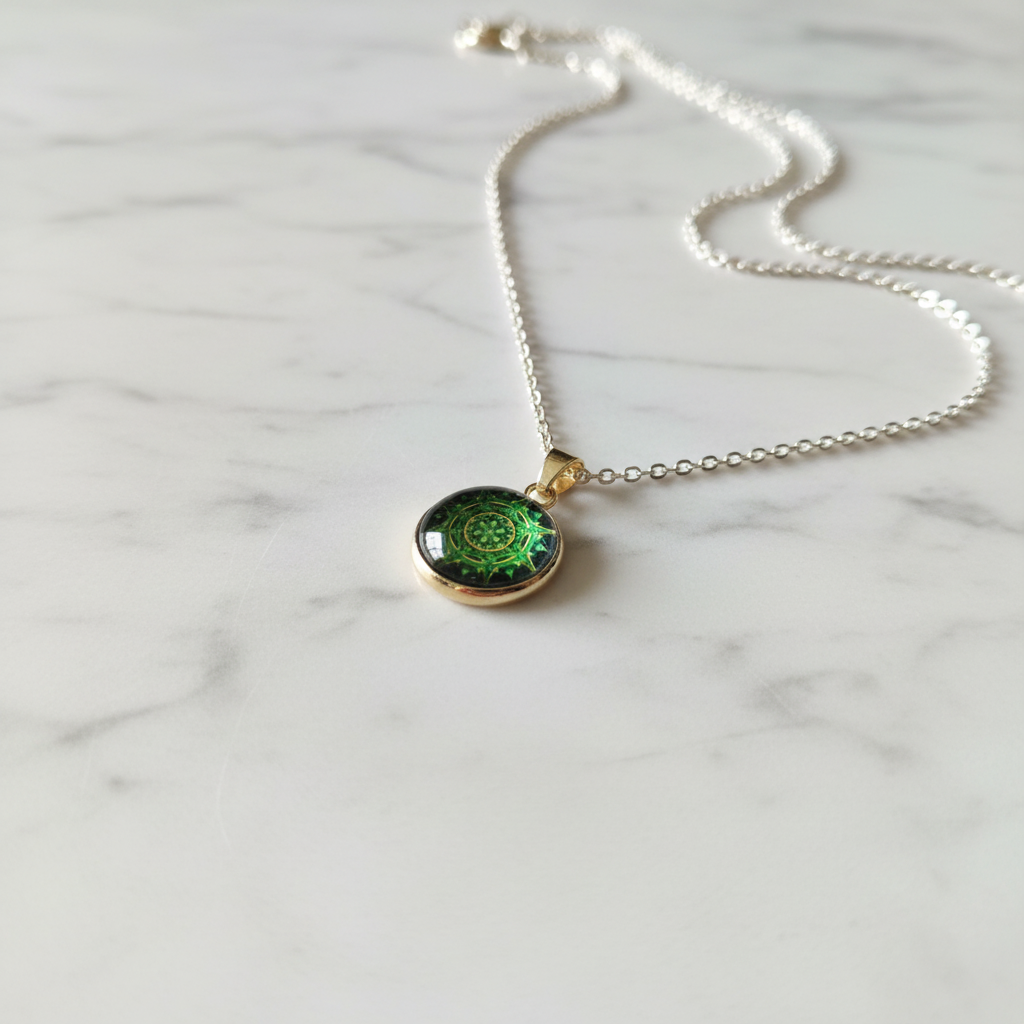 Green spiral mandala petite pendant necklace angled view on marble surface