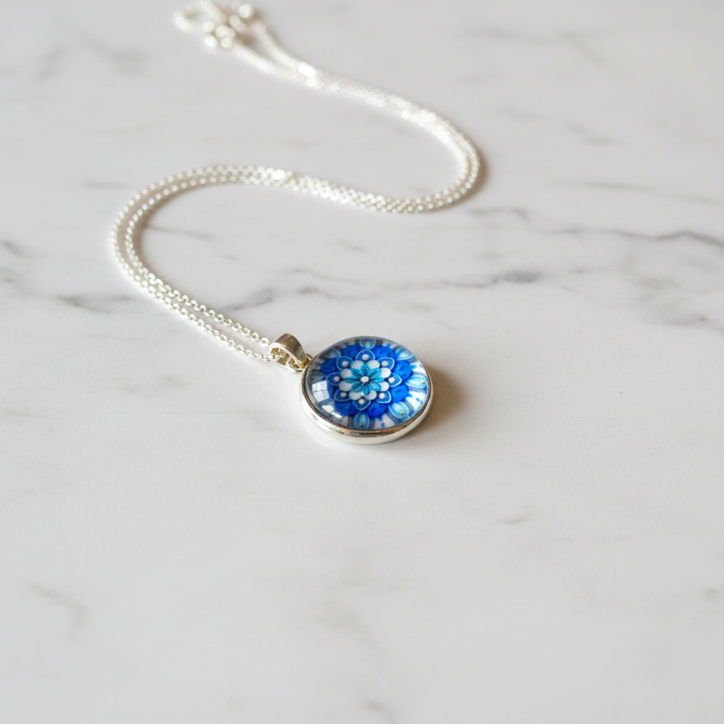 Blue flower mandala petite pendant necklace angled view on marble surface