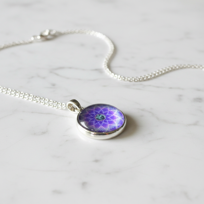 Purple Om mandala petite pendant necklace angled view on marble surface