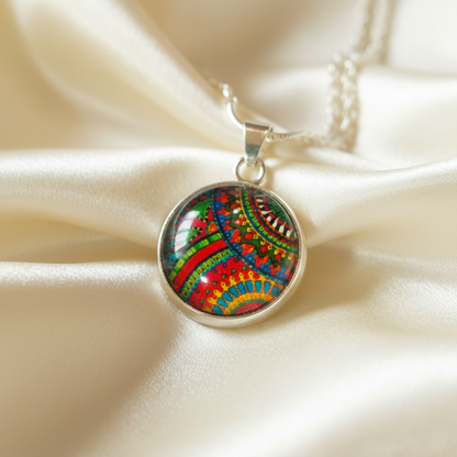 Close-up of glass dome cabochon rainbow paisley pendant on satin