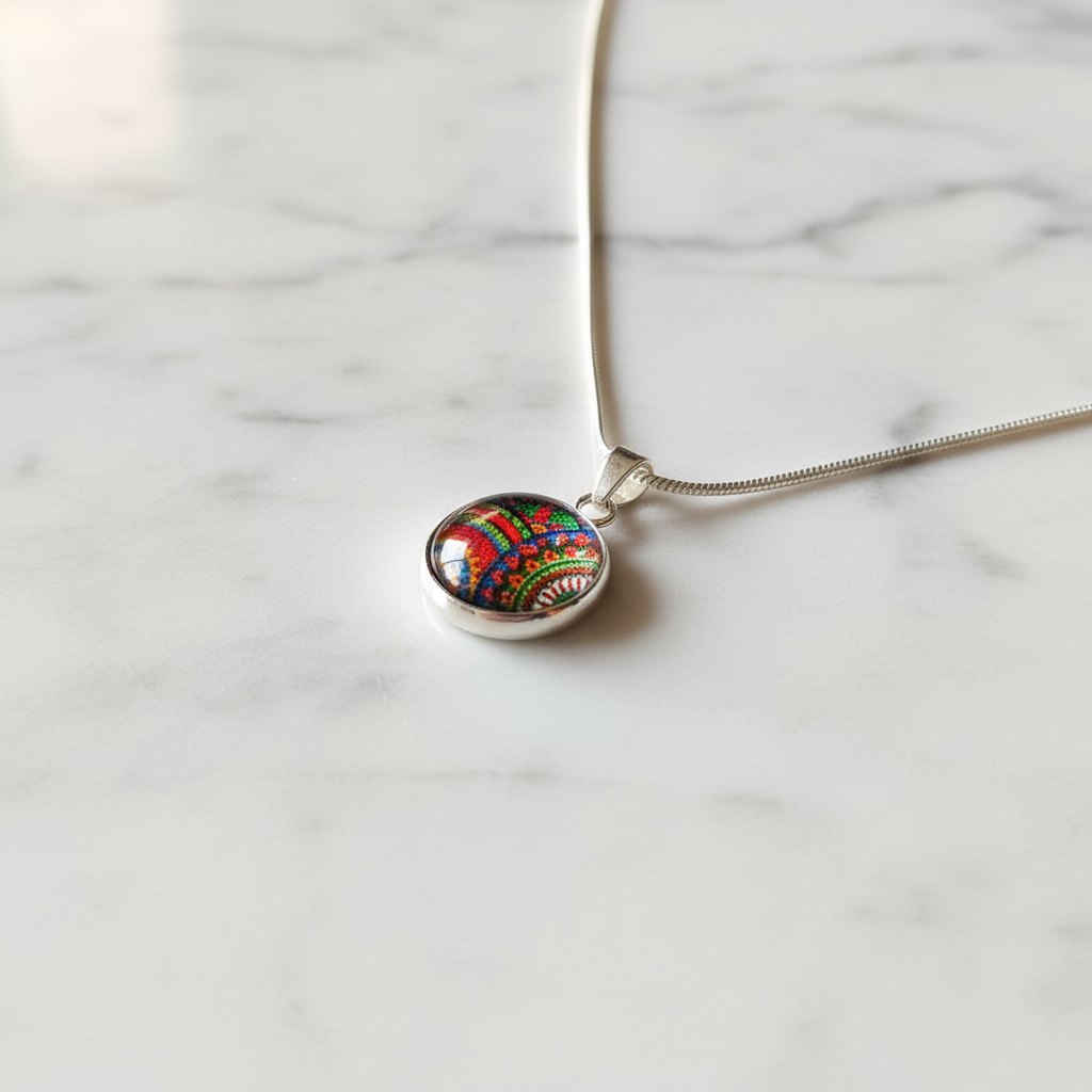 Rainbow paisley petite pendant necklace angled view on marble surface