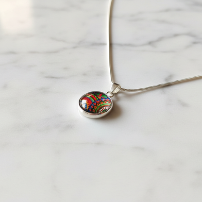Rainbow paisley petite pendant necklace angled view on marble surface