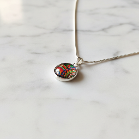 Rainbow paisley petite pendant necklace angled view on marble surface